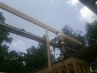 Carpenter setting a ridge beam over a new addition frame — Ice Dam Removal by Roofing Brothers in Rayville