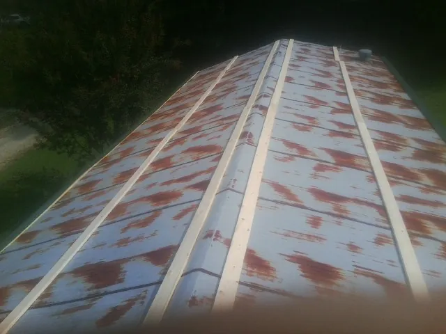 Rusted metal roof panels with new wood purlins before replacement — Storm Damage Roof Repair in Rayville by Roofing Brothers