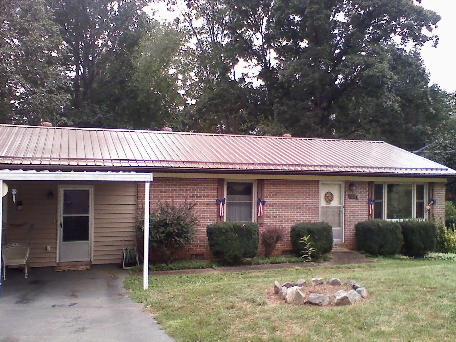 Bronze metal roof and carport on a brick ranch home — Roof Repair work by our crew in Rayville
